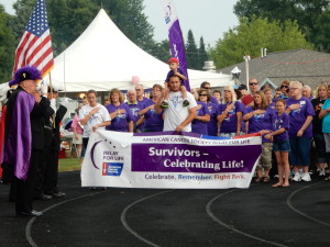 Attendees prepare for the survivor's lap while listening to the National Anthem.
