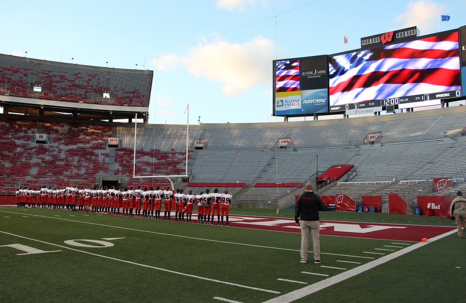 Spencer/Columbus coach Jason Gorst and the team watch an American flag on one of the video screens as the national anthem is played before the Rockets lost to Amherst 42-0 in the WIAA Division 5 State Championship Game at Camp Randall Stadium in Madison, Thursday, Nov. 19, 2015.