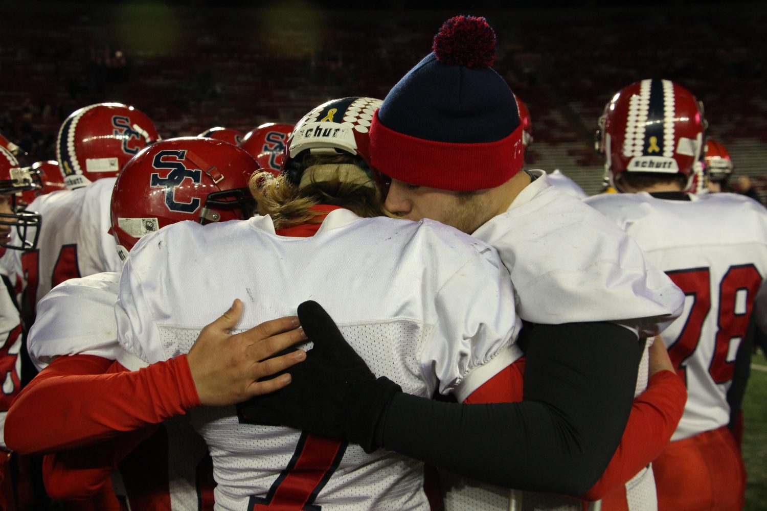 From left, Carson Hildebrandt, Calvin Lenz, and Brett Loveland hug after the Rockets lost to Amherst 42-0 in the WIAA Division 5 State Championship Game at Camp Randall Stadium in Madison, Thursday, Nov. 19, 2015.