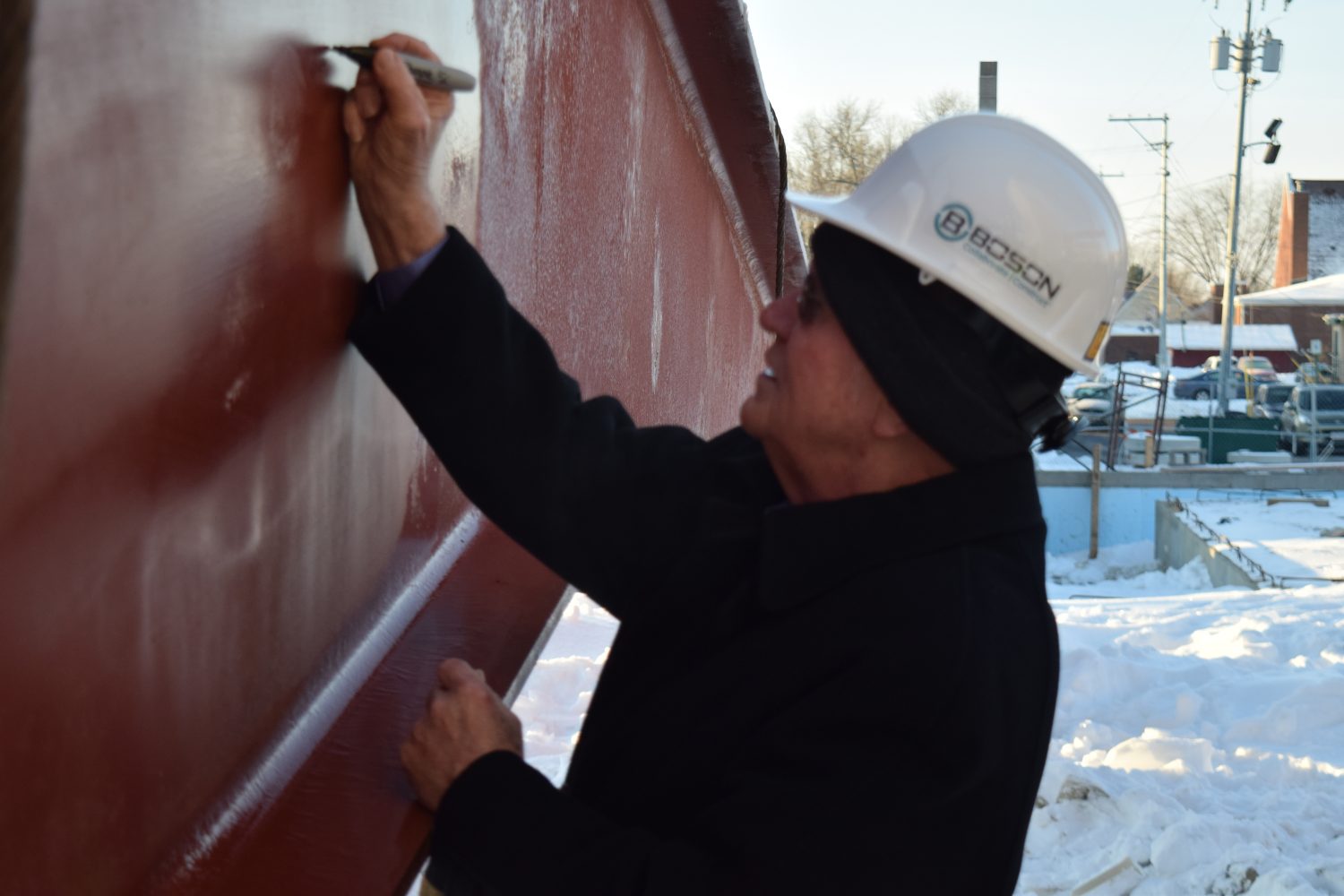 Everett Roehl signs a beam before it is put in place on the new Everett Roehl Marshfield Public Library.