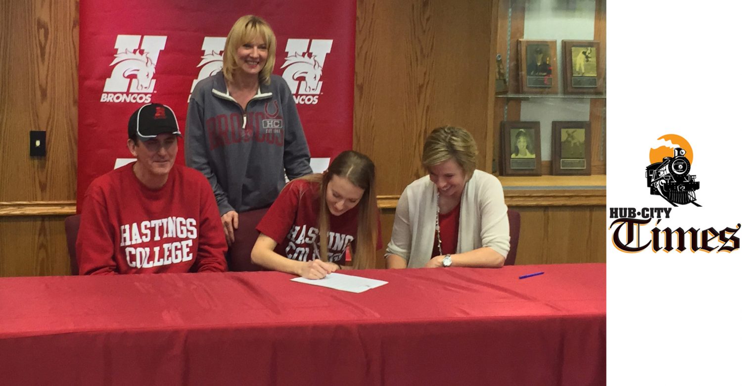 Marshfield Columbus Catholic High School senior Jessica Trad, seated in the middle, signed a letter of intent to play basketball at Hastings College in Hastings, Neb., last weekend. Trad's father, Dr. Michael Trad, is to her left, and Hastings coach Jina Johansen is to her right. Trad's mother, Suzan Trad, is standing.