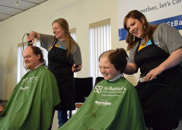 Left to right: Father and son Brave the Shave as Katie Niemerg shaves Scott Boushons head, and Alisa Barlow shaves John Boushons head.