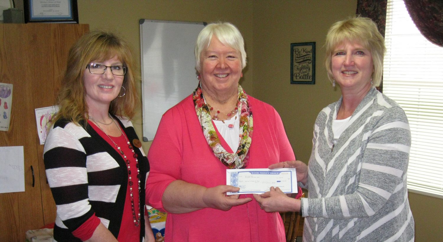 From left to right: Heritage bank employee Janet Kleinschmidt, Sue Poole of Shirley’s House of Hope, and Heritage Bank employee Kathy Meidl pose with a donation check to the domestic violence shelter.