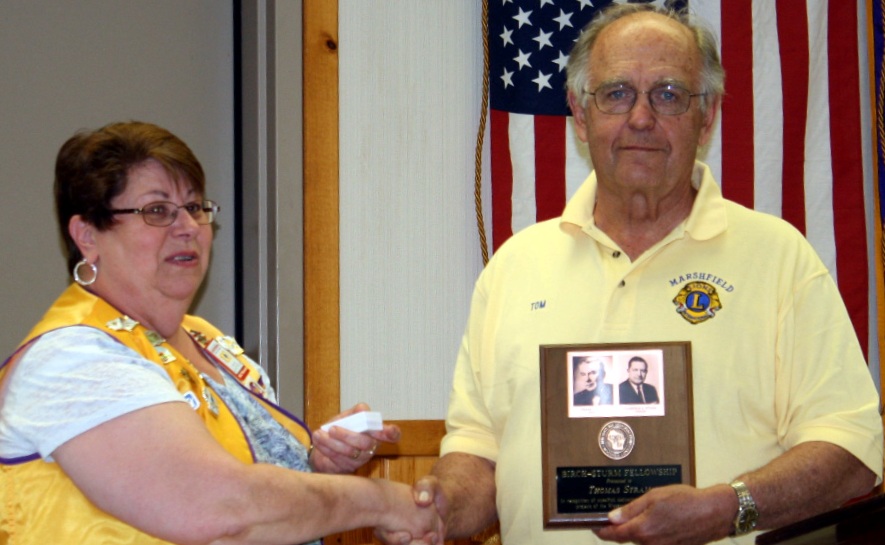 Past Marshfield Lions Club President Lily Michalski presents Thomas Stram with a plaque in honor of his Birch-Sturm Fellowship.