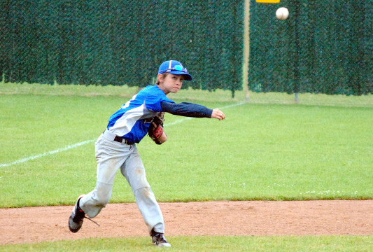 A St. Croix Falls U12 third baseman throws to first for an out during a game at Olson Field East in last year's Small Town Baseball Tournament in Marshfield.