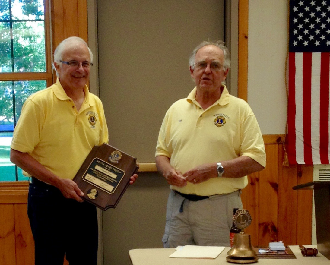 Tom Ptack, left, receives a plaque in honor of his Melvin Jones Fellowship from Marshfield Lions Club President Thomas Stram.
