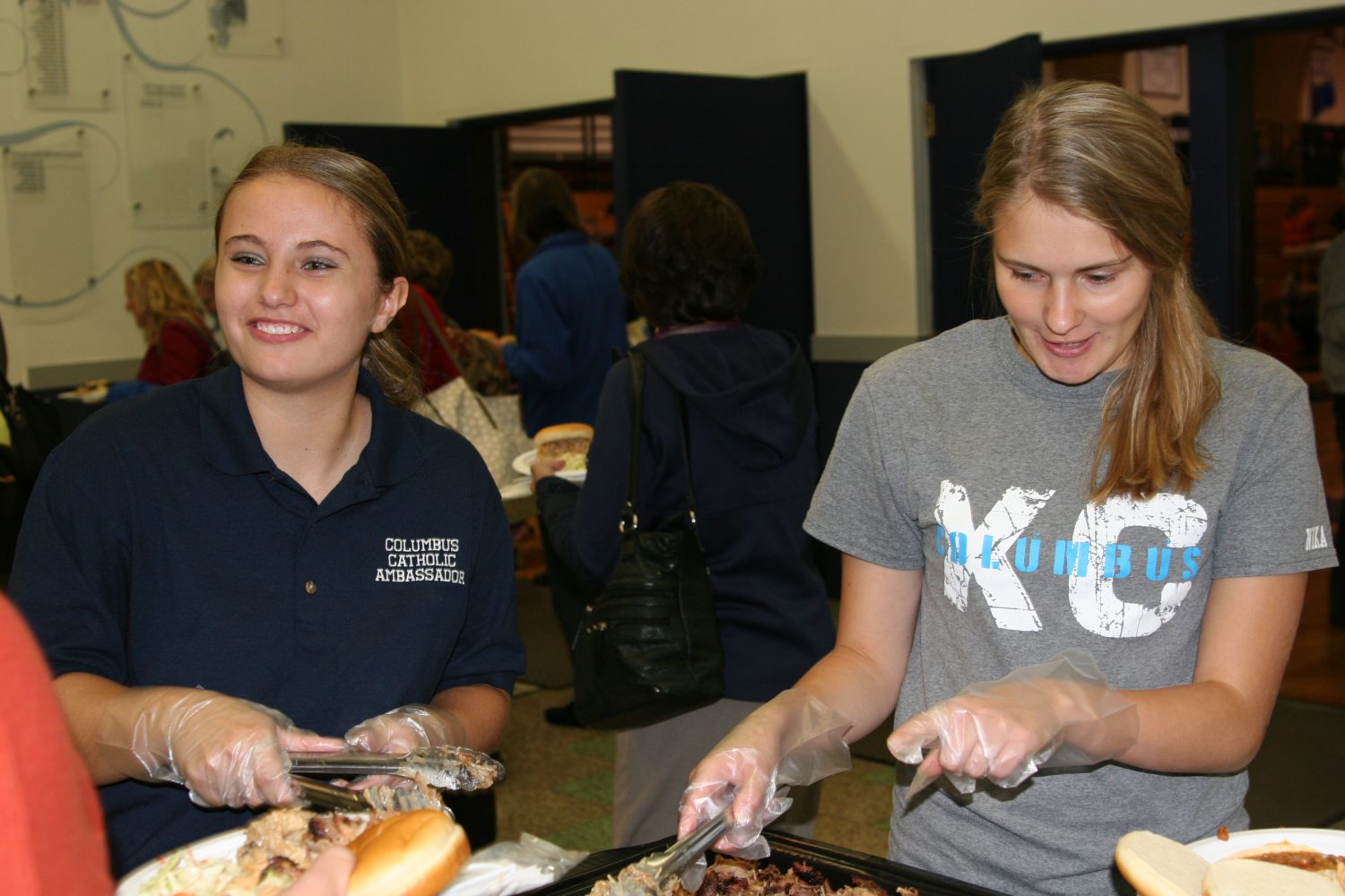 Sierra Litwaitis (left) and Polish foreign exchange student, Dominika Lukjan (right) serve Diocese of La Crosse faculty and staff while fundraising for Home Delivered Meals. Hub City Times staff photo.
