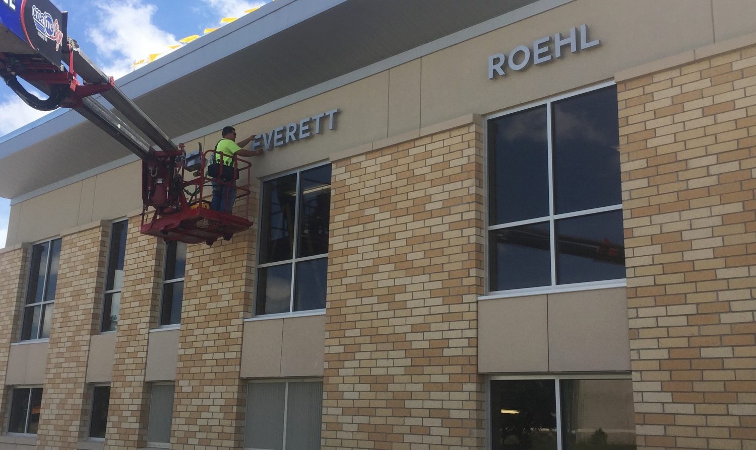 Trent Nolan with Creative Sign Company Inc. from De Pere installs the letter “e” sign on the Everett Roehl Marshfield Public Library on July 12.