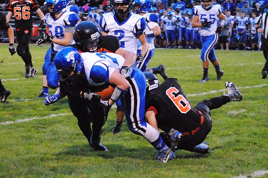 Marshfield’s Paul Maguire and Austin Goode (6) wrap up an Oshkosh West ball carrier during the Tigers’ 34-13 win on Friday at Beell Stadium.
