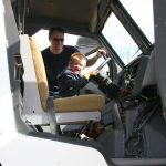 Emerson Lightfoot takes the controls of the Marshfield Police Department armored rescue vehicle, as his dad, Travis Lightfoot holds on. Hub City Times Staff photo.