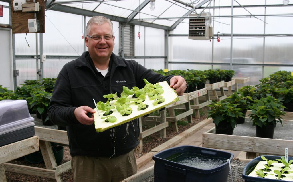 Spencer agriculture education instructor Mark Zimmerman holds up a batch of hydroponic — growing without soil — lettuce, a technique he learned while working as an intern for Disney and now uses in his courses.