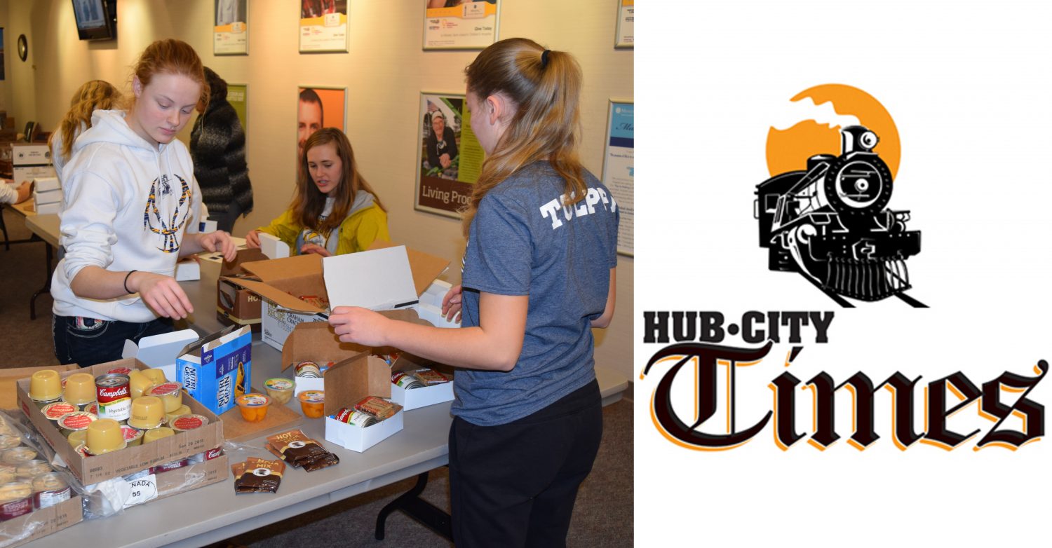 Emily Nemitz, left, and Taylor Tolppi pack boxes of nonperishable items for the Home Delivered Meals program on Dec. 22.