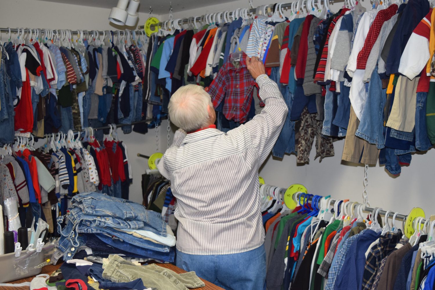 Volunteer Darlene Schmidt sorts through children's garments that are available at the Hannah Center to those in need.
