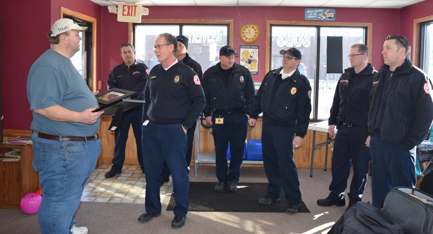 Scotty's Pizza & Chicken owner Scott Berg, far left, receives two plaques from members of Marshfield Fire & Rescue Department for his dedication to Marshfield's Fire Prevention program.