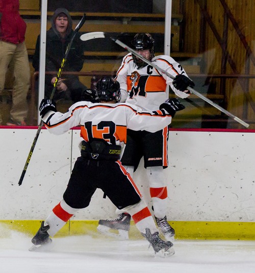 Marshfield’s Zach Schmidt and Colin Barth celebrate Schmidt’s goal during the second period of the Tigers’ win over Regis/Altoona/McDonell on Saturday at the Marshfield Youth Ice Arena.