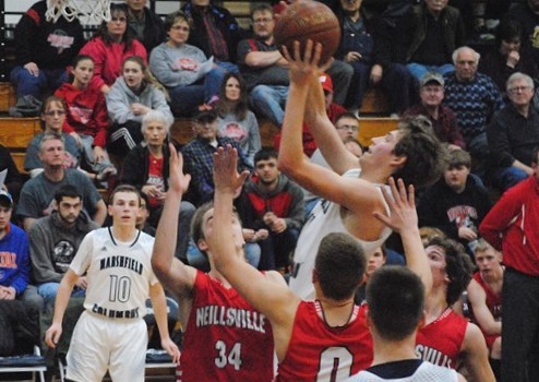 Columbus Catholic’s Noah Hansen goes up for a basket surrounded by Neillsville defenders during a boys basketball game Monday at Columbus Catholic High School. The Dons won 83-45 to clinch sole possession of the Cloverbelt Conference East Division championship.