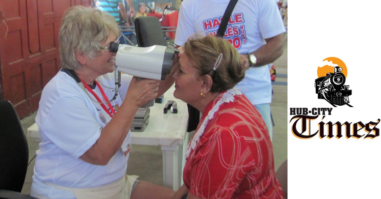 Volunteer Mary Griepentrog, left, uses an autorefractor on an eyeglass recipient.