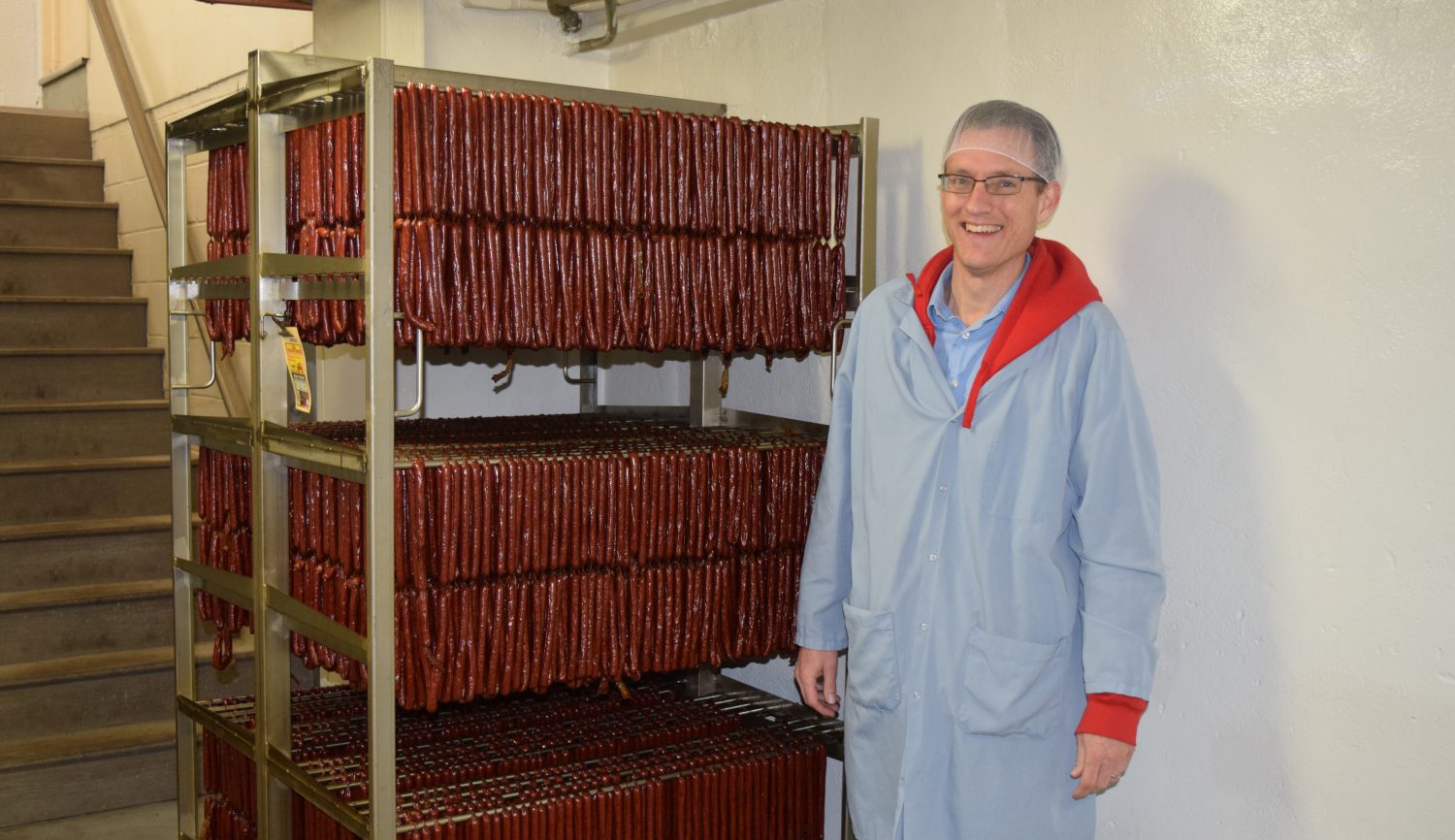 Wenzel’s Farm President Mark Vieth stands next to cooling sausage sticks inside the Wenzel plant.