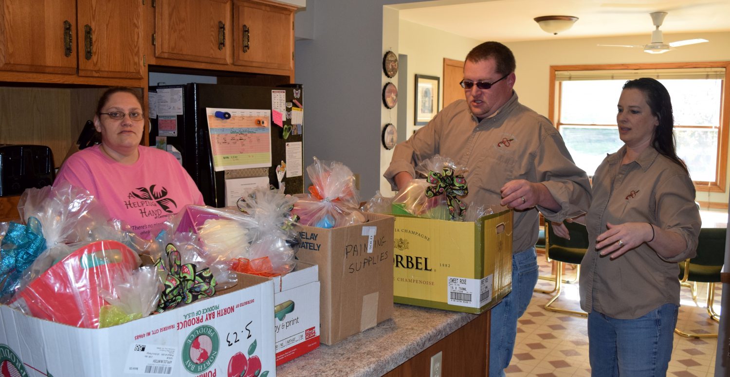 From left: Resident JoAnn McCracken and Illusions & Design owners Rick and Sheri Dana unpack donation baskets at the Hannah Center on May 14.