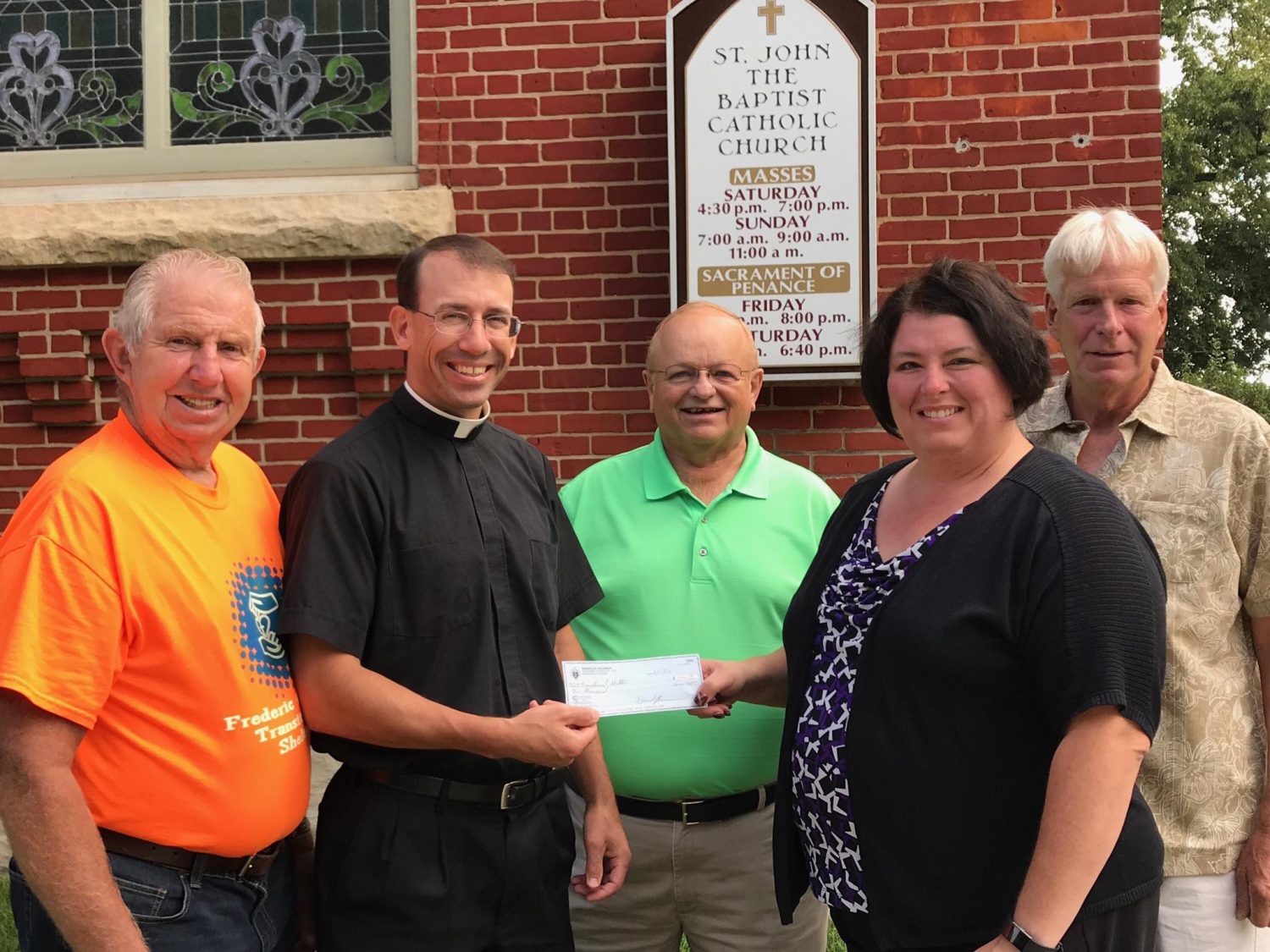 The Rev. Samuel Martin (second from left), pastor of St. John the Baptist Catholic Church in Marshfield, presents a check to Tammy Schueller, Frederic Ozanam Family Shelter director. In the back row from left are Jerry Lang, St. Vincent de Paul Thrift Store/Outreach Center board of directors president; Tom Youngwith, president of St. Johns Conference of the Society of St. Vincent de Paul; and Paul Lang, Frederic Ozanam Family Shelter board of directors president.