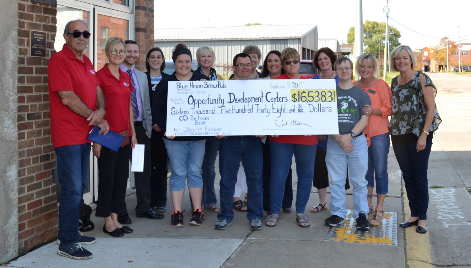 Posing with a check for the more than $16,500 raised during the Blue Heron BrewPub’s Oktoberfest on Sept. 9 are representatives of Opportunity Development Centers, beneficiaries of the event, and the BrewPub.